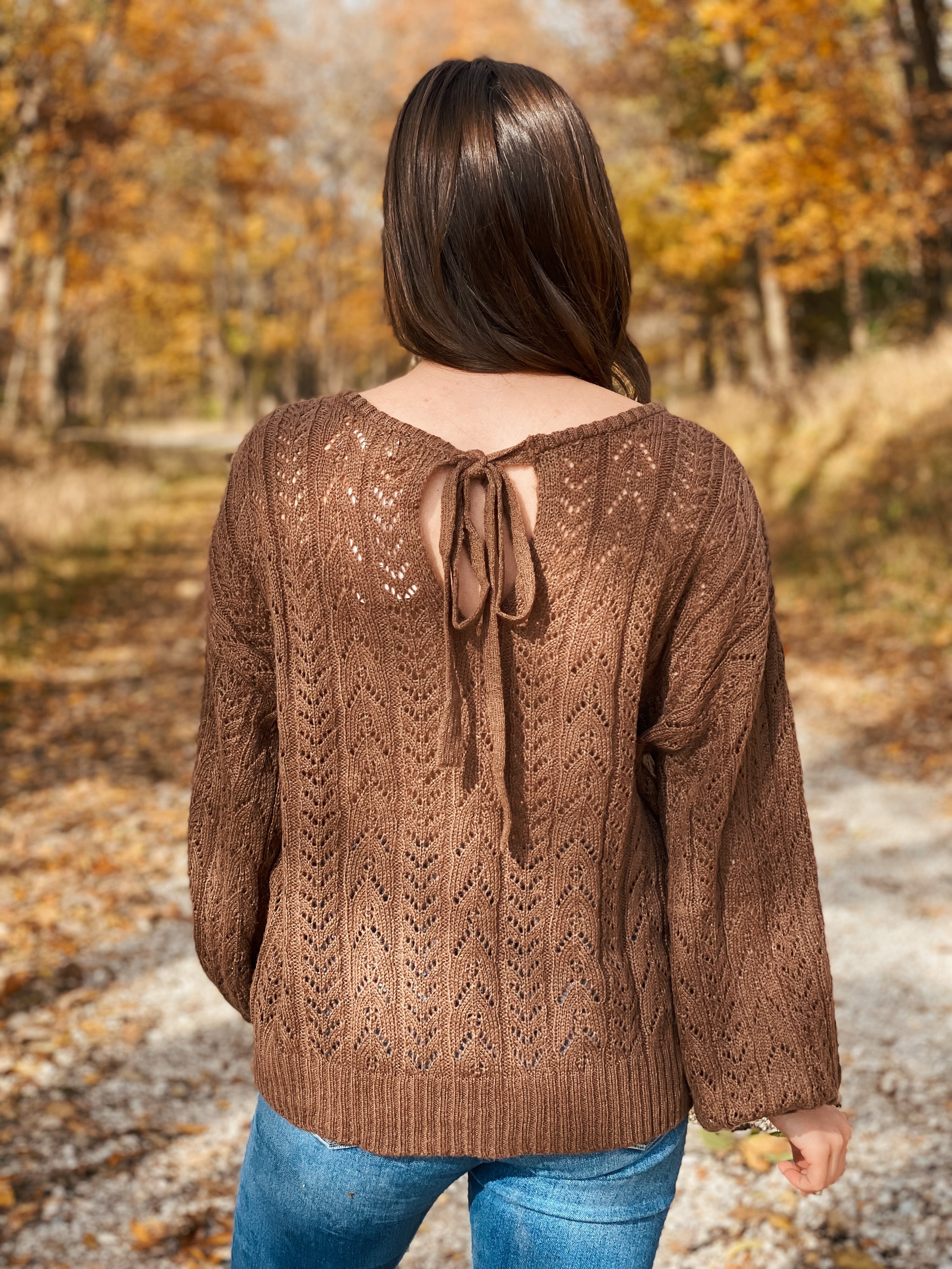 This beautiful brown eyelet sweater is soft and comfortable. The back has a cute bow tie.