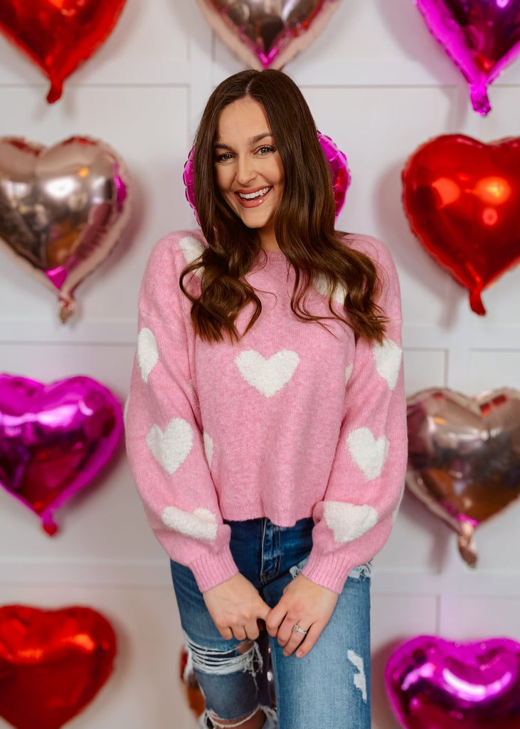 Pink knit sweater with white heart pattern
