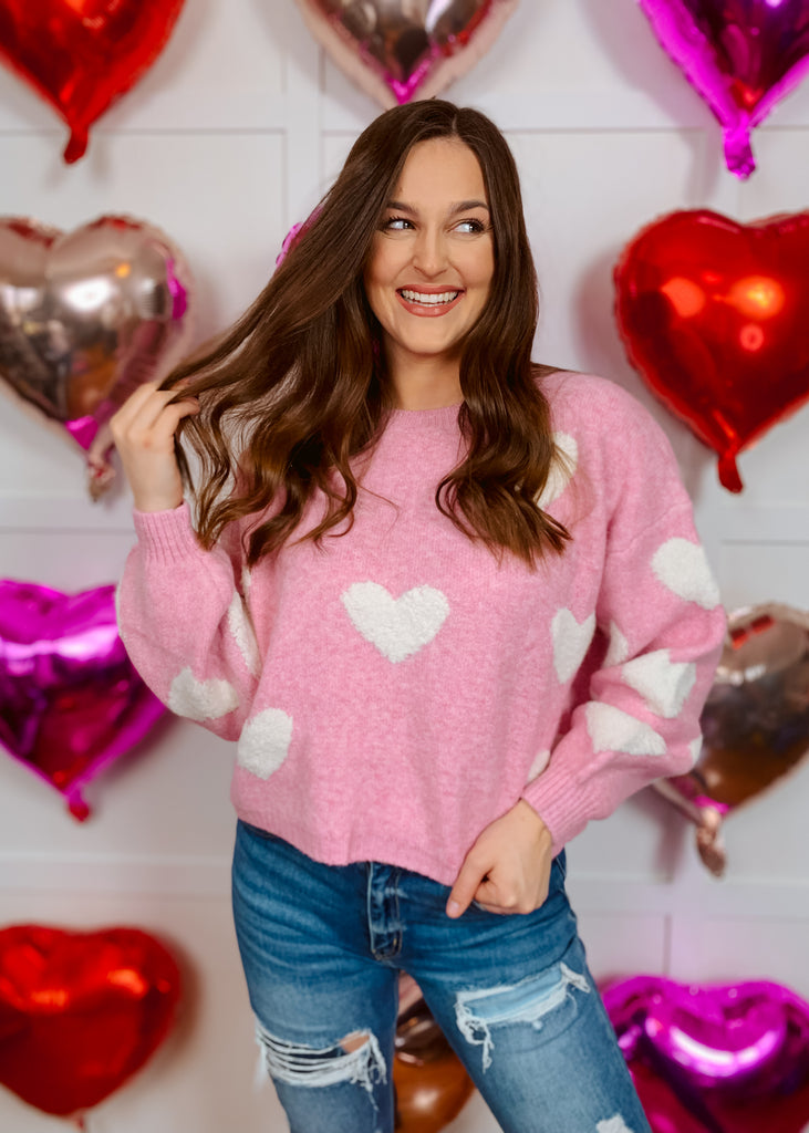 Pink knit sweater with white heart pattern